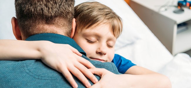 Niño abrazando padre camisa verde